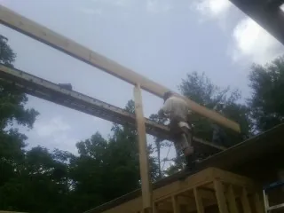 Carpenter setting a ridge beam over a new addition frame — Ice Dam Removal by Roofing Brothers in Coal Township