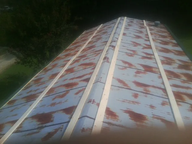 Rusted metal roof panels with new wood purlins before replacement — Storm Damage Roof Repair in Coal Township by Roofing Brothers