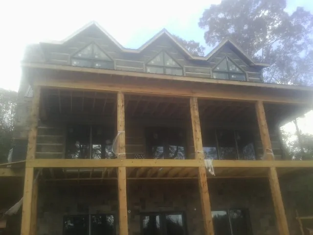 Dormers and porch framing on a large log home under construction — Roof Coating work by our crew in Coal Township