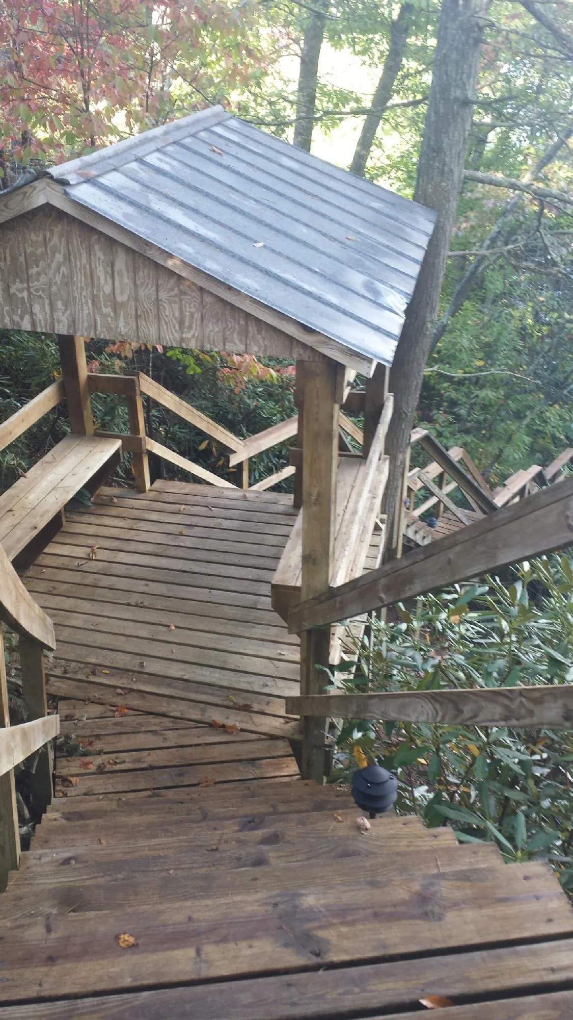Metal roofed shelter over wooden steps on a wooded walkway — Skylight Repair & Installation work by our crew in Coal Township