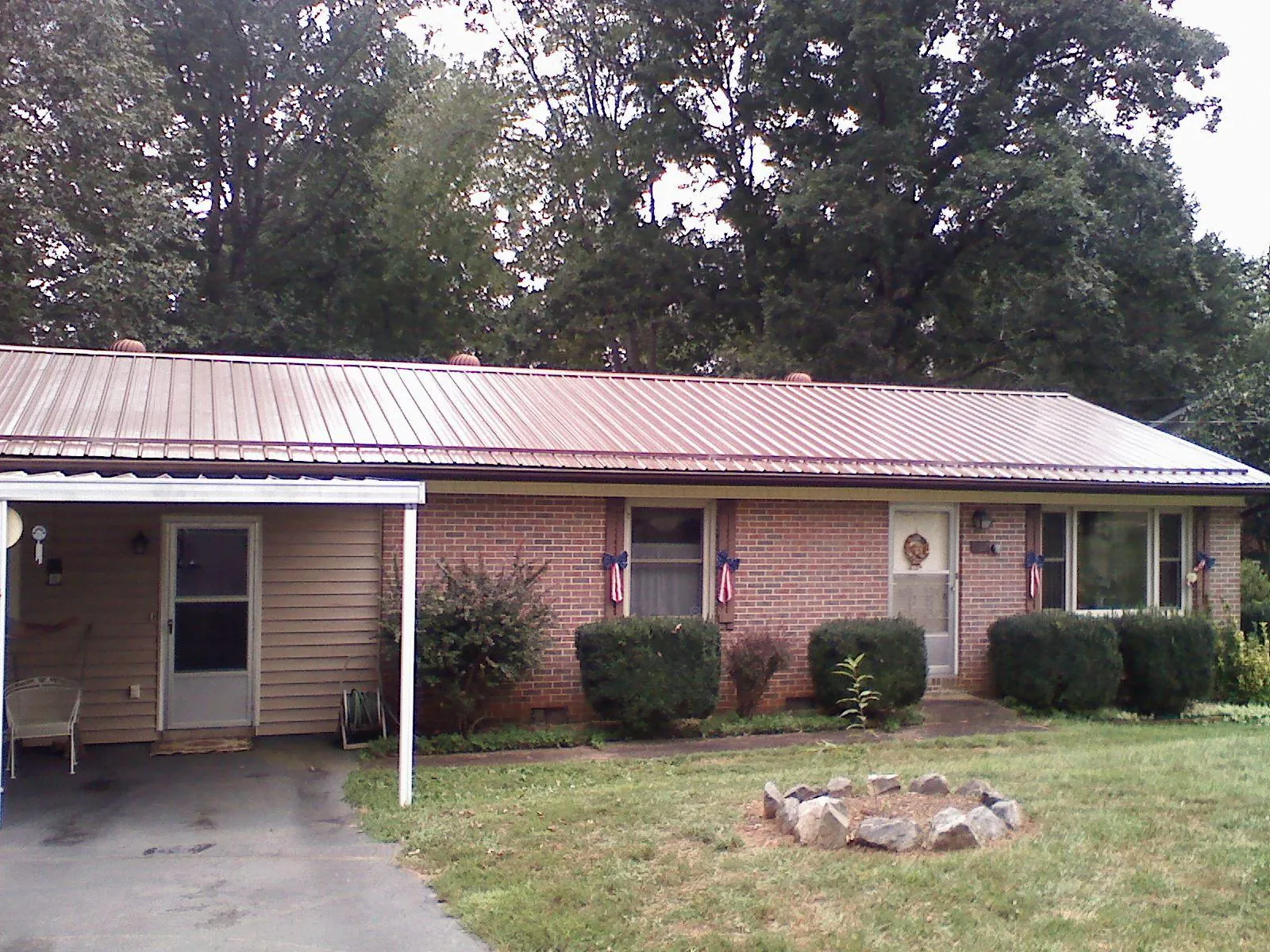 Bronze metal roof and carport on a brick ranch home — Roof Repair work by our crew in Coal Township