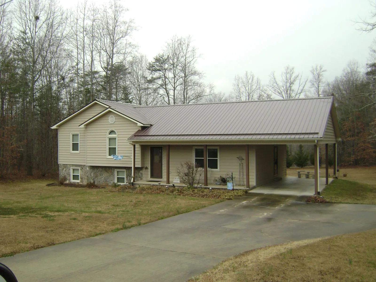 Brown metal roof on a tan split level home with an attached carport in Coal Township